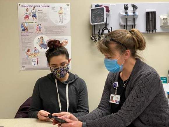 Two women looking at diabetic screening test.