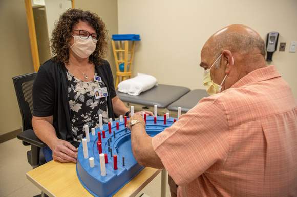 Therapist smiling at patient doing an exercise
