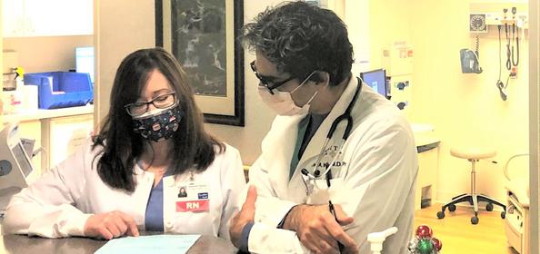 Jen Hickey, RN and David Knight, MD, PhD reviewing a patient chart.